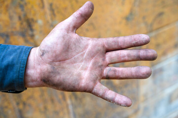 Work-worn hand showing signs of hard labor after a long day outdoors