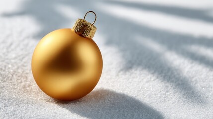 Golden christmas ball on the snow with shadow isolated on white background