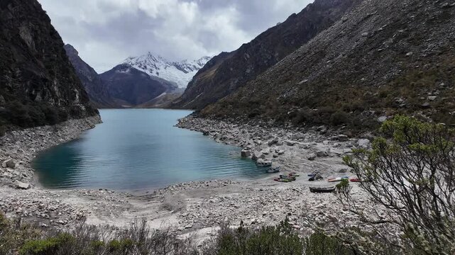 Huaraz, Peru: Panoramic footage of the Laguna Paron with a dramatic sky and the Piramide Peak in Cordillera Blanca, a famous mountain lake near Caraz in Peru in the Huascar&aacute;n National Park
