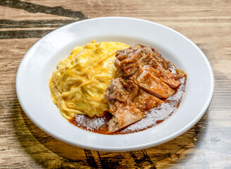 Japanese Omelette Rice with Pork Chop Cutlet and Savory Sauce Omurice with Katsu Style in plate on wooden table high angle view of asian cousin