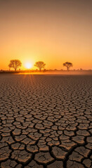 Sunset over cracked, arid landscape.