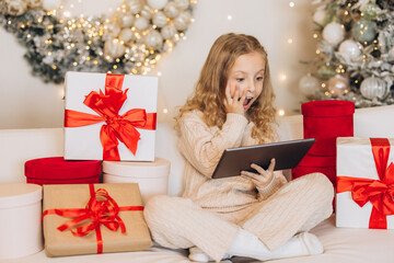 Excited Child with Tablet Surrounded by Christmas Gifts