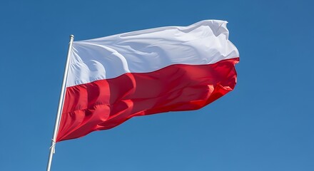 Polish flag waving with blue sky.