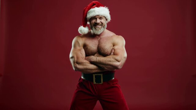 Muscular Santa Claus flexing with arms crossed on a bold red background, blending strength with festive holiday spirit.