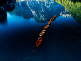 Charming rowboats float on a serene lake, beautifully nestled among breathtaking mountains
