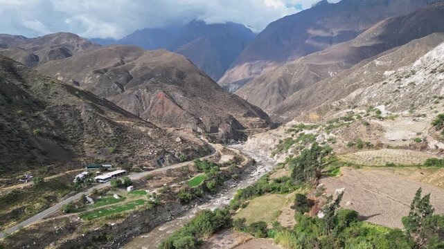 Huaraz, Peru: Forward aerial drone footage above the river flowing in valley of canon del pato in Huaraz region, Peru with dramatic mountains in the background