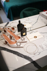 Elegant bridal high heels with crystal embellishments next to a wedding invitation sealed with a heart wax stamp.