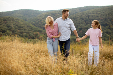 Family enjoys a day out in nature during a warm afternoon surrounded by green hills