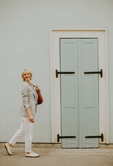 Woman walks past decorative door in the French Quarter