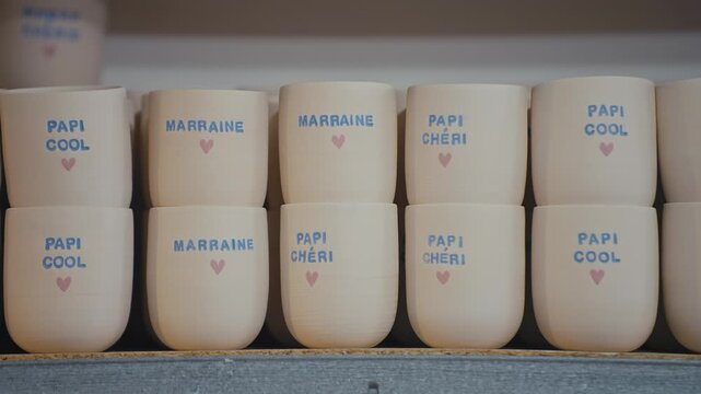 Handmade Ceramic Mugs with French Text on Shelf