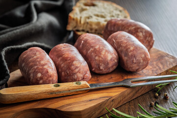 Photo of italian sausage salsiccia on cutting board on wooden table.
