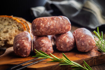 Photo of italian sausage salsiccia on cutting board on wooden table.