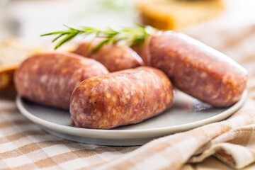 Photo of italian sausage salsiccia on plate on checkered napkin.