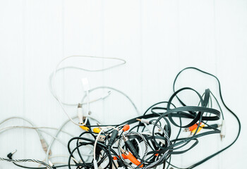 Tangled cords and cables on a table. Space organization concept.