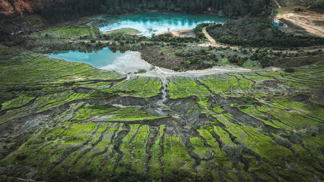 Stunning aerial view of a natural landscape featuring a serene blue lake and interesting geological shapes.