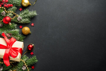 Black Christmas flat lay background. Holiday decorations with present box and Christmas tree on...