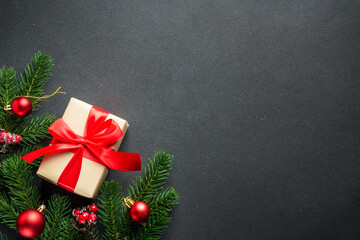 Black Christmas flat lay background. Holiday decorations with present box and Christmas tree on black with copy space.