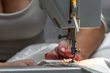 Sewing fabric bouncle on a sewing machine at home workshop