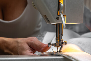 Sewing fabric bouncle on a sewing machine at home workshop