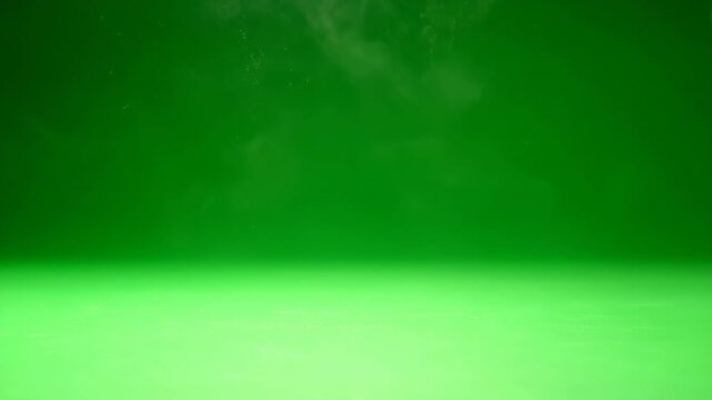 Delicate dust motes slowly falling from above onto a clean green screen floor in soft light calm, background, compositing