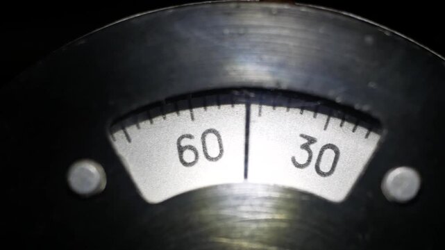 A mechanical dial is spinning ,a countdown from 0 to 300,illuminated in the dark.