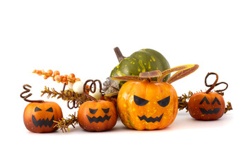 Halloween still life with small jack-o'-lantern pumpkins, pinecones, autumn leaves, and white background