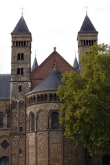 Obraz premium Romanesque Church With Twin Towers in Maastricht, Autumn Day, Historic Brick Architecture