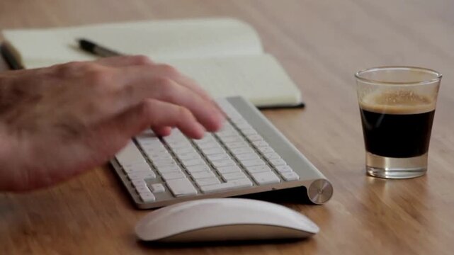 Productive Remote Work: Typing, Note-Taking, and Drinking Coffee on a Modern Wooden Desk