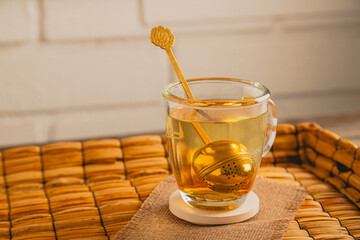 Golden Tea Infuser Steeping in a Glass Mug