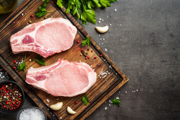Raw pork steak. Fresh meat on cutting board with spices.