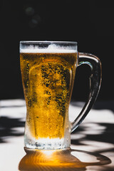 50 cl pint of beer served on wooden surface. Cold beer glass on wooden table. Refreshing golden beer in glass on wooden table. Full glass of lager beer on wooden table.