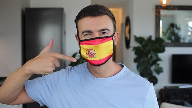 Man using a protective breathing mask with the Spanish flag on it 