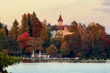 Evening atmosphere at sunset on the shore of Villette Park in Cham, with a view of St. Andreas...