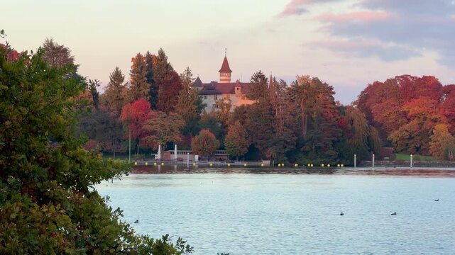 Evening atmosphere at sunset on the shore of Villette Park in Cham, with a view of St. Andreas Castle.