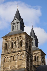 Fototapeta premium Maastricht Cathedral Twin Towers in Autumn Light: Historic Brick Church with Sloped Steeples
