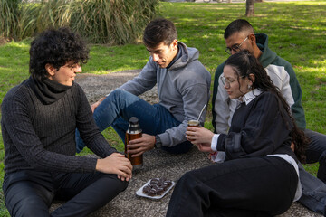 Group of young friends sharing traditional mate and argentinian alfajores outdoors