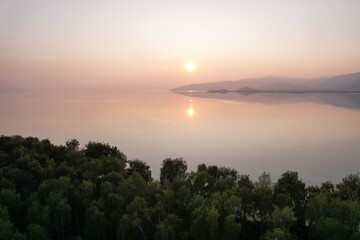 Obraz premium Calm lake reflecting sunrise light at dawn