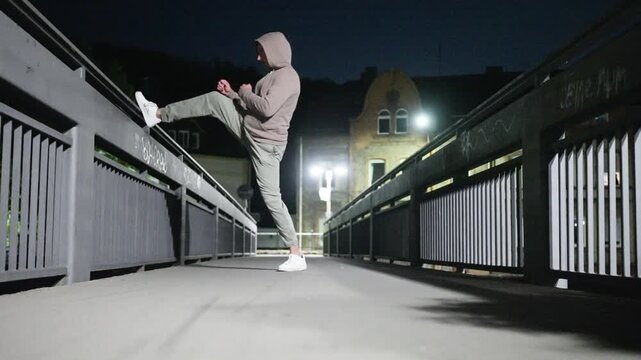 solitary figure trains at night, nighttime training session highlighting dedication and flexibility