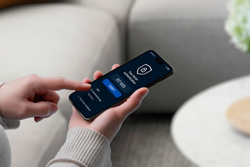User entering 2FA code on smartphone screen with security shield icon, representing secure login,...