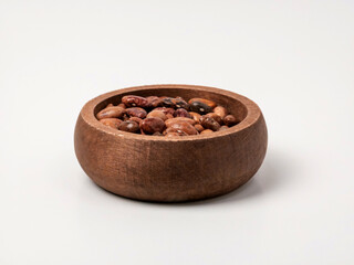 Mixed dried beans in a rustic wooden bowl isolated on white