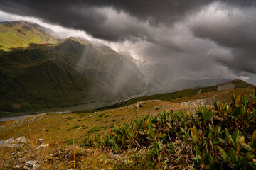 Sunlight Breaking Through Storm Clouds Over The Caucasus Mountains Near Ushguli Georgia: Dramatic Landscape Of Light, Shadow And Wilderness