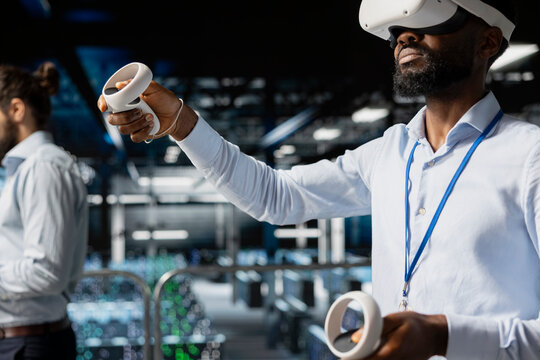 System administrator with VR headset using artificial intelligence technology for neural network infrastructure. Developer using AI programming language and virtual reality to update hardware.