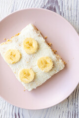 Close-Up of a Banana Coconut Cream Cake on a Pink Plate
