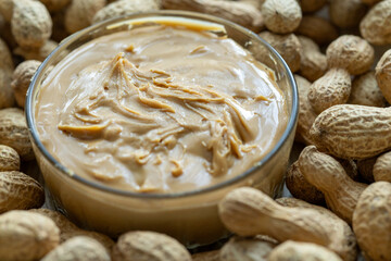 Close-Up of Peanuts on a Wooden Plate with a Bowl of Peanut Butter in the Center
