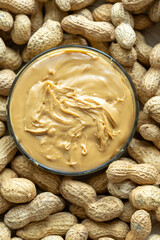 Close-Up of Peanuts on a Wooden Plate with a Bowl of Peanut Butter in the Center
