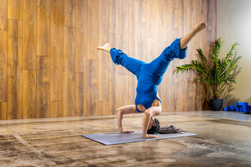 Yoga instructor performing headstand pose in studio