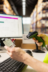 Asian male worker scanning airway bill numbers for order fulfillment and inventory control, using a...