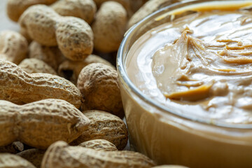 Close-Up of Peanuts on a Wooden Plate with a Bowl of Peanut Butter in the Center
