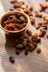 Dried Raisins in a Copper Bowl on a Brown Wooden Table

