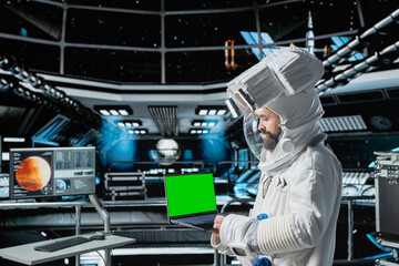 Astronaut checks isolated screen laptop interface before landing spaceship on Mars. Crew member looking at mockup notebook during mission to red planet surface, testing human survival in deep space